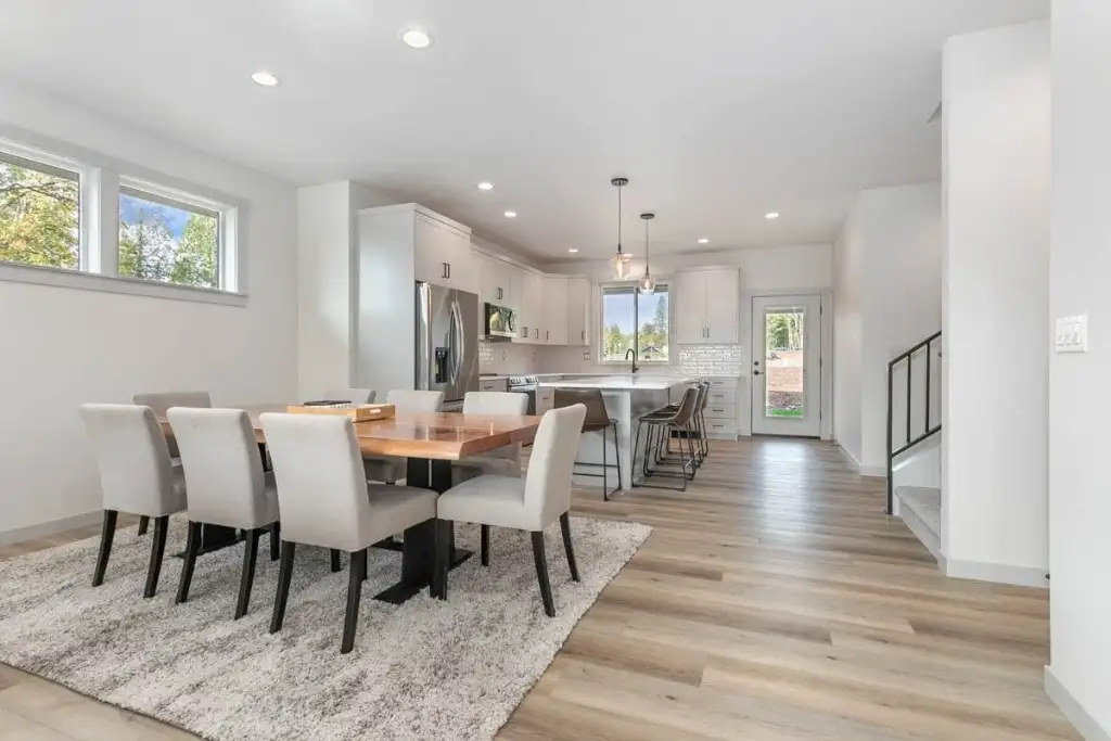 Open dining area in plan 280263JWD with a walnut table, clerestory windows and the kitchen and stair beyond