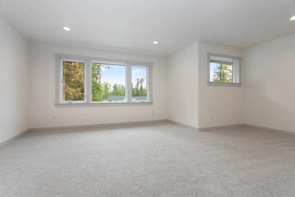 Large carpeted upstairs room in plan 280263JWD with a three-window bank and a second window on the return wall