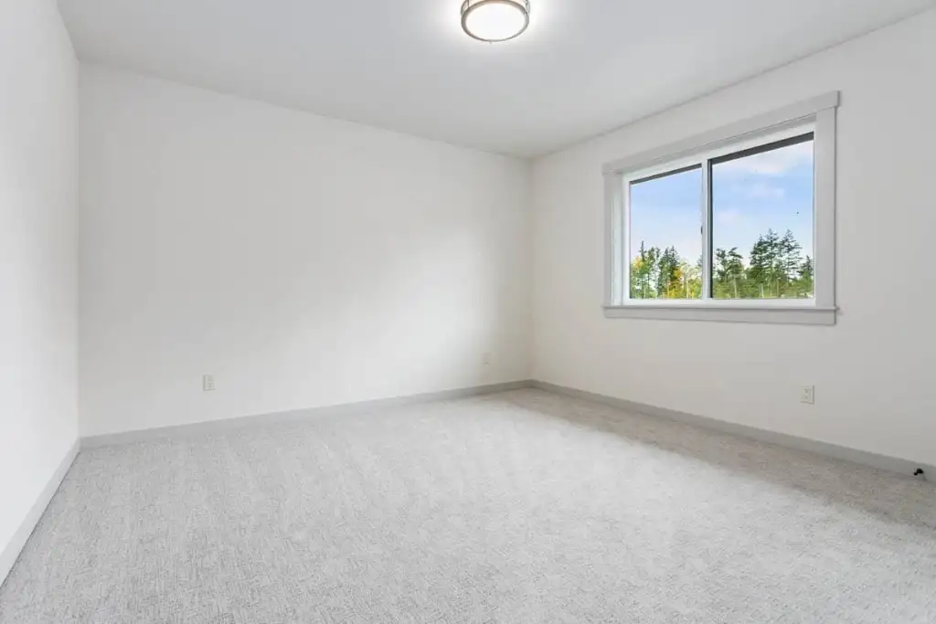 Secondary bedroom in plan 280263JWD with a corner window, carpet and a flush ceiling light