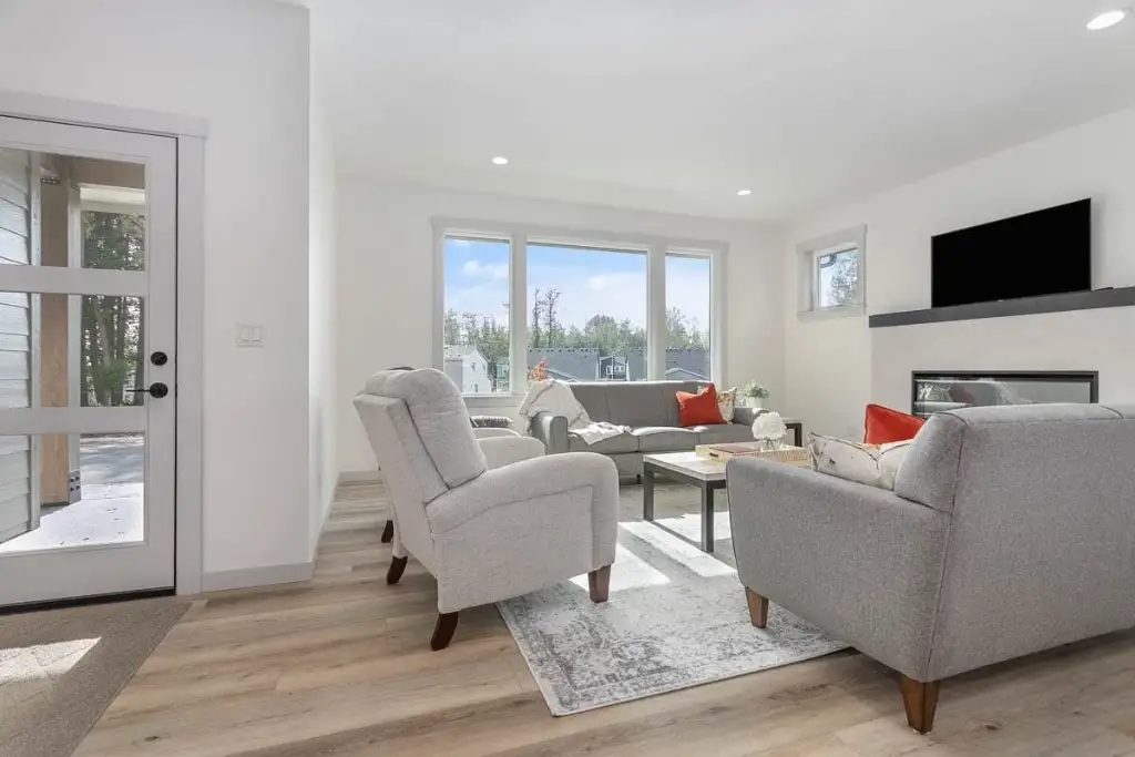 Living room of plan 280263JWD from the entry, showing the glass door to the covered patio and the fireplace wall