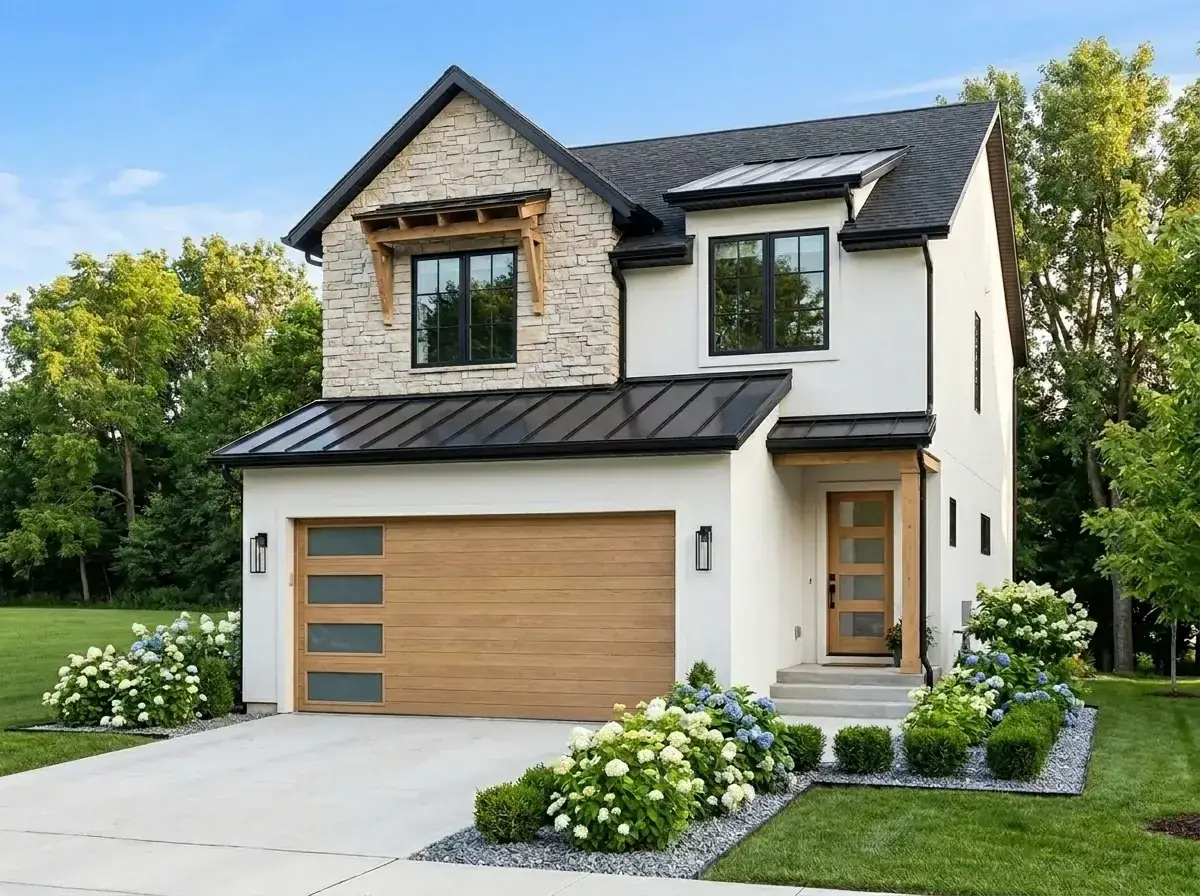 Textural modern farmhouse facade with white stucco base, stacked stone veneer gable, light wood garage door, and abundant white hydrangea landscaping